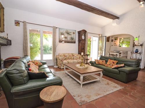 a living room with green leather couches and a table at Villa Les Angevines by Interhome in Morières-lès-Avignon