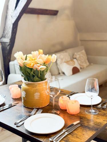 a table with plates and glasses and a vase of flowers at LouLou Home's in Antwerp