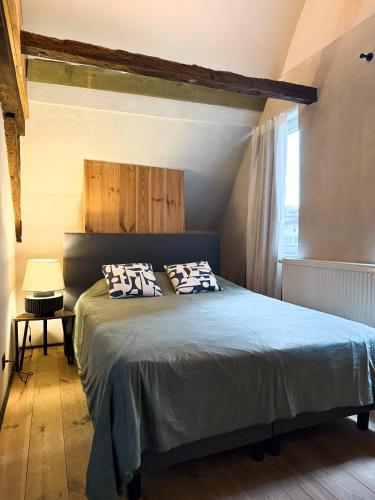 a bedroom with a bed with two pillows on it at LouLou Home's in Antwerp