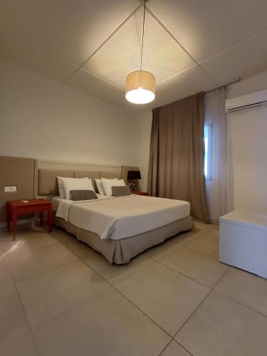 a bedroom with a large bed and a light at Atlantis Boutique ΑΝΝΕX in Rhodes Town