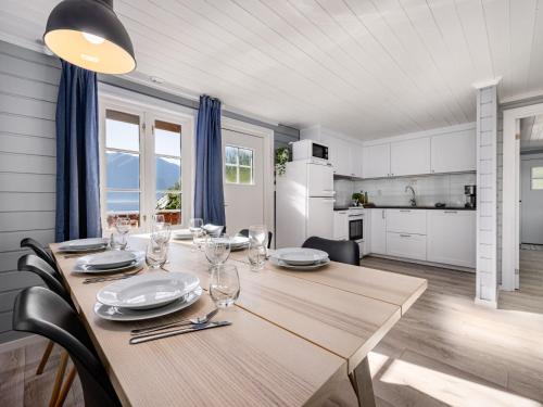 a dining room with a wooden table and a kitchen at Holiday Home Tor by Interhome in Arnefjord