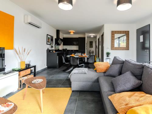 Il comprend un salon avec un canapé gris et une cuisine. dans l'établissement Holiday Home palot 17 by Interhome, à Mimizan