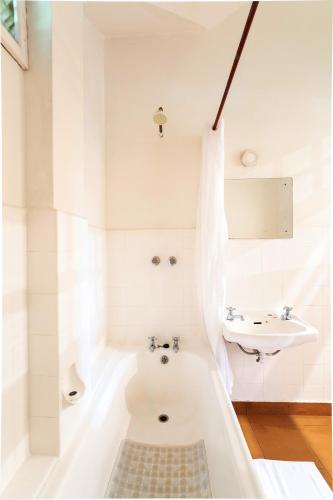 a white bathroom with a tub and a sink at Masindi Hotel in Masindi