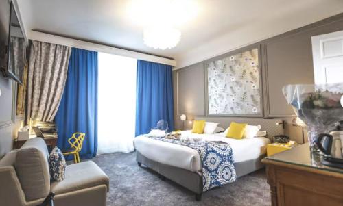 a hotel room with a bed and a couch at Grand Hotel Bellevue - Grand Place in Lille
