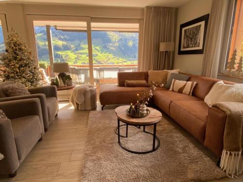 a living room with a couch and a christmas tree at Apartment Alpenrose by Interhome in Adelboden