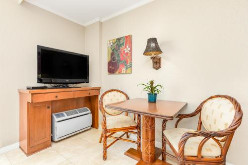 a dining room with a table and a tv at Luana Waikiki Hotel & Suites in Honolulu