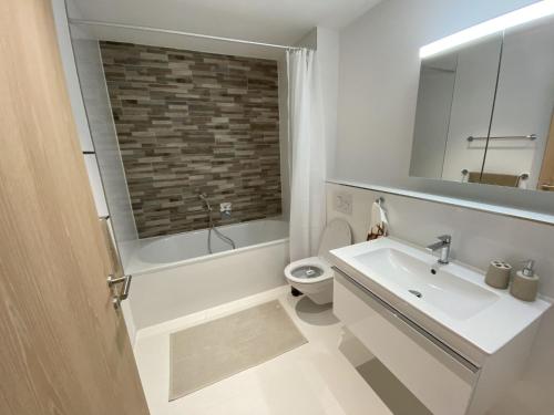 a bathroom with a sink and a toilet and a mirror at Apartment Alpenrose by Interhome in Adelboden