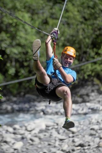 a man is hanging on to a rope on a river at Apartment Alpenrose by Interhome in Adelboden