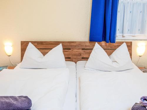 two beds with white pillows in a room at Holiday Home Kiel by Interhome in Norddeich