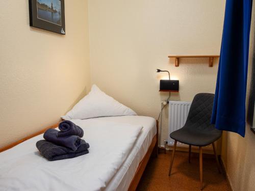 a small room with a bed and a chair at Holiday Home Kiel by Interhome in Norddeich
