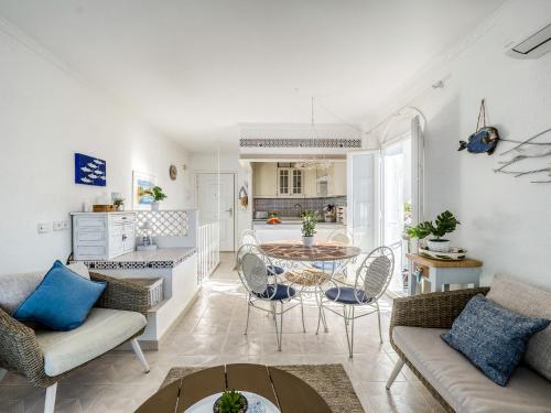 Una sala de estar con mesa y sillas y una cocina. en Holiday Home Los Geranios by Interhome, en Roses