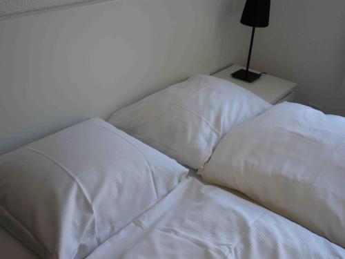 two white pillows sitting on a bed in a room at Apartment Près du Bahnhof by Interhome in Engelberg
