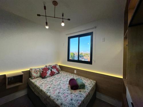 a room with a small bed with a window at APTO TESLA Novo,com Piscina e Ar condicionado in São Carlos