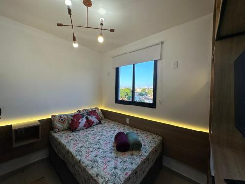 a room with a bed with a hat on it at APTO TESLA Novo,com Piscina e Ar condicionado in São Carlos