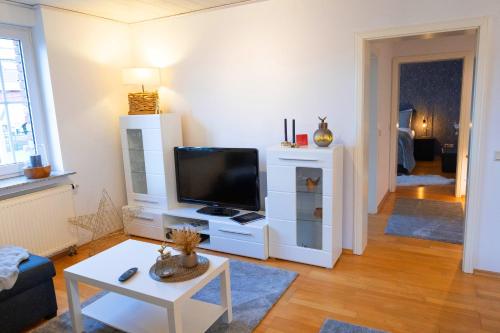a living room with a tv and a white entertainment center at Ferienwohnung Menden in Menden