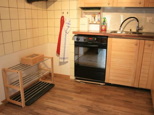 a kitchen with a sink and a black oven at Apartment Chalet Bifigen by Interhome in Kandergrund