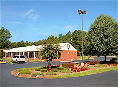 a building with a car parked in a parking lot at Yorktown Motor Lodge in Yorktown