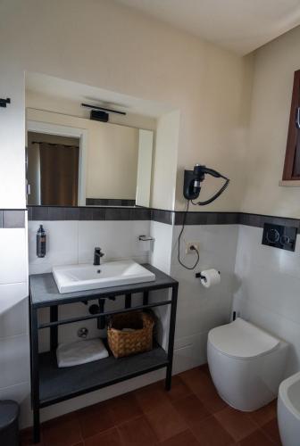 a bathroom with a sink and a toilet and a mirror at Tenuta del Duca Fiumicino Locanda e Hostaria Guest House in Fiumicino