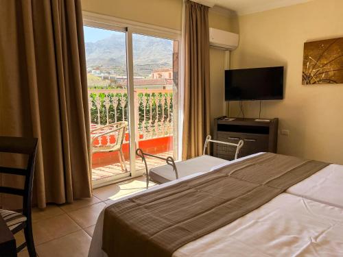 a hotel room with a bed and a large window at Hotel La Aldea Suites in La Aldea de San Nicolas