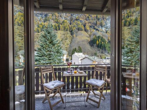 a table and chairs on a balcony with a view at Apartment Isola di Madesimo Apartments-1 by Interhome in Isola