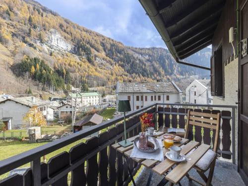 a table on a balcony with a view of a mountain at Apartment Isola di Madesimo Apartments-1 by Interhome in Isola