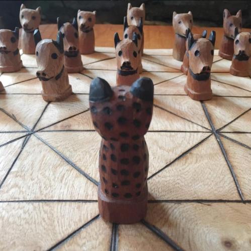 a group of wooden figurines of dogs on a table at La Aldea De La Selva Lodge in Puerto Iguazú