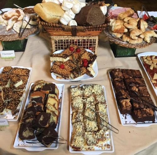 a table with many different types of bread and pastries at La Aldea De La Selva Lodge in Puerto Iguazú