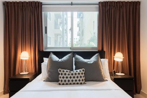 a bedroom with a bed with two lamps and a window at Armonia 24 suites by Yellowkey in Los Prados