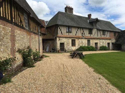 a large building with a picnic table in front of it at La Ferme du Chateau in Fauguernon