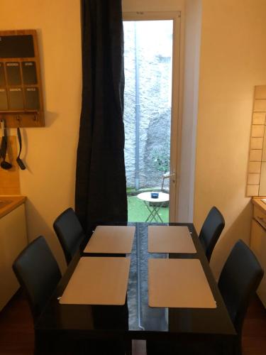 une pièce avec une table, des chaises et une fenêtre dans l'établissement Victor Hugo Confort et sa pizza offerte, à Aurillac