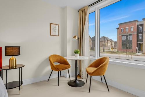 ein Zimmer mit zwei Stühlen und einem Tisch und einem Fenster in der Unterkunft Bright & Stylish Modern Townhome in Oakville! in Oakville