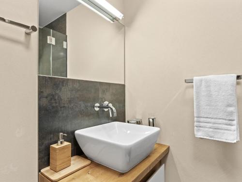 a bathroom with a white sink and a mirror at Apartment Kulm 1 by Interhome in Valbella