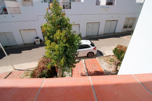 a white car parked in a parking lot next to a tree at Luna de Mojácar in Mojácar