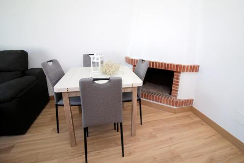 a dining room table with chairs and a fireplace at Luna de Mojácar in Mojácar
