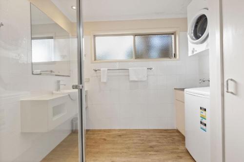 un baño con ducha y lavabo en Westwind - Waterfront Retreat, en Goon Nure