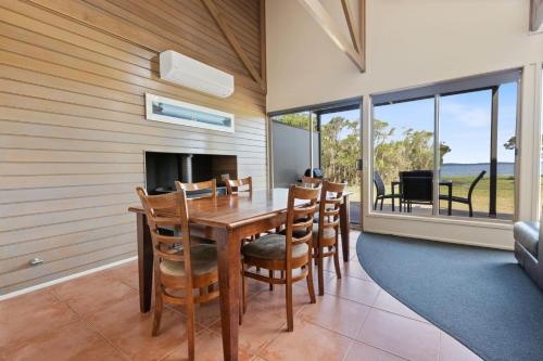 a dining room with a table and chairs and a fireplace at Avon - Waterfront Retreat in Goon Nure