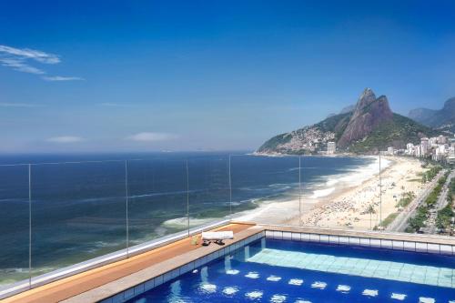 a pool with a view of the beach and the ocean at Sol Ipanema Hotel in Rio de Janeiro