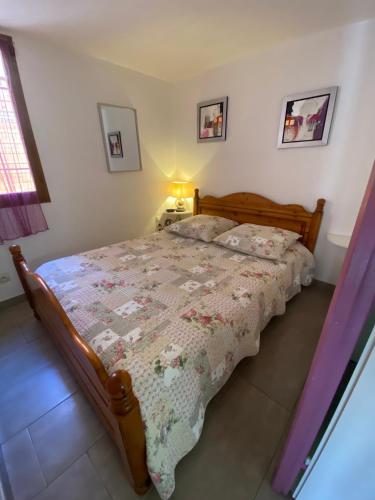 une chambre avec un lit avec une couette dessus dans l'établissement Villa 5 pers climatisée terrasse et parking proche plage - V0264, à Vias
