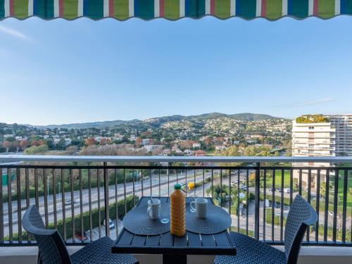 une table sur un balcon avec vue sur une ville dans l'établissement Apartment Le Surcouf by Interhome, à Mandelieu-la-Napoule