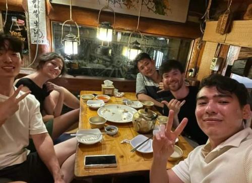 a group of people sitting around a table at Zen Seoul Stay in Seoul