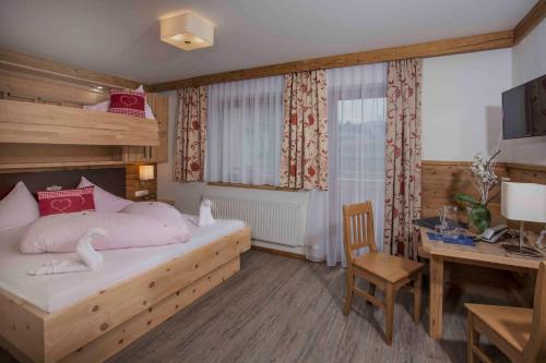 a bedroom with a bed and a desk and a desk at Gasthof zum Wilden Kaiser in Scheffau am Wilden Kaiser