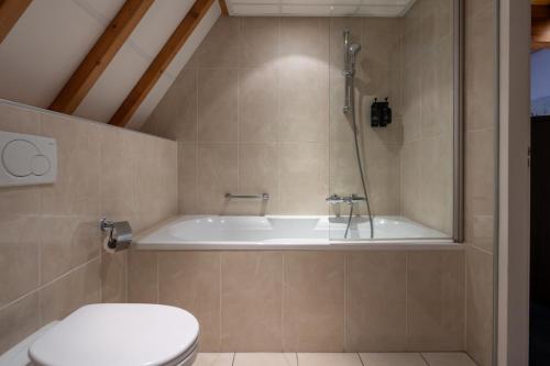 a bathroom with a bath tub and a toilet at Boutique Hotel Maldegem in Vlissingen