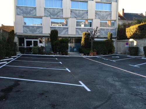 an empty parking lot in front of a building at Bristol Logis Cit'Hotel Périgueux Centre in Périgueux