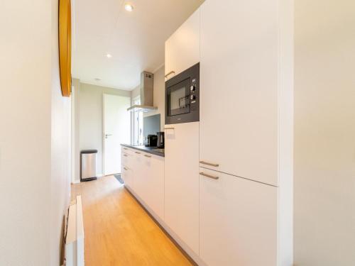 a kitchen with white cabinets and a microwave at Vacation Home in Haarle near Hellendoorn in Haarle