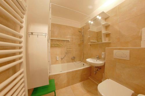 une salle de bain avec toilettes, baignoire et lavabo dans l'établissement Apartment Süd-Panorama mit Pool & Sauna, à Hohegeiss