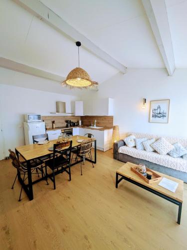 un salon avec une table, des chaises et un canapé dans l'établissement 42 m2 d'élégance avec terrasse, parking, belle vue, à Collioure