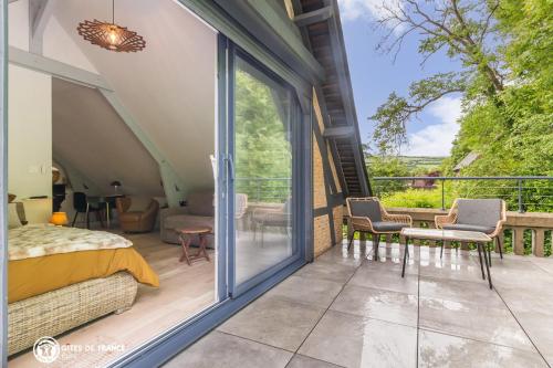 a bedroom with a bed and a balcony with a view at Villa du Vieux Château in Les Andelys