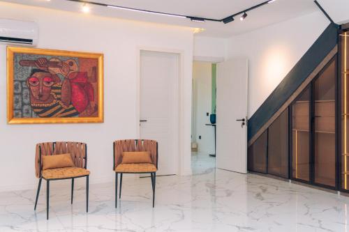 two chairs in a room with a painting on the wall at Wakatee Apartments - Luxury 2 bedrooms Apartment in Victoria Island