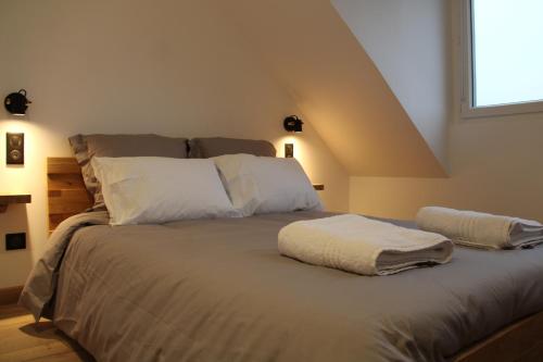 a bedroom with a bed with white pillows and a window at Appart Côte d'Opale in Condette