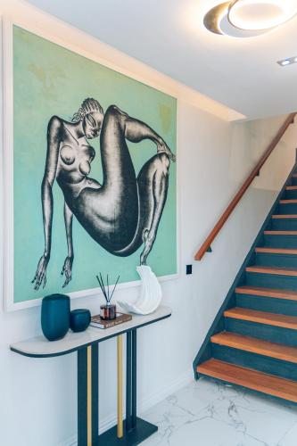 a painting of two mermaids on a wall next to a staircase at Wakatee Apartments - Luxury 2 bedrooms Apartment in Victoria Island